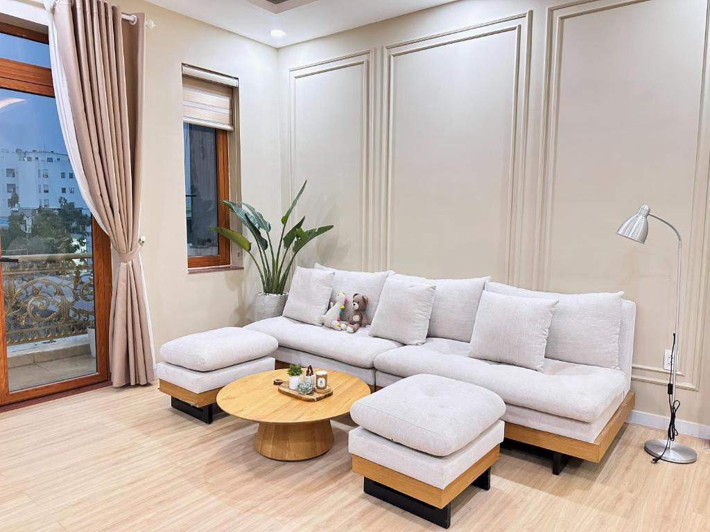 胡志明市Secret Elm Hotel的客厅配有白色的沙发和桌子