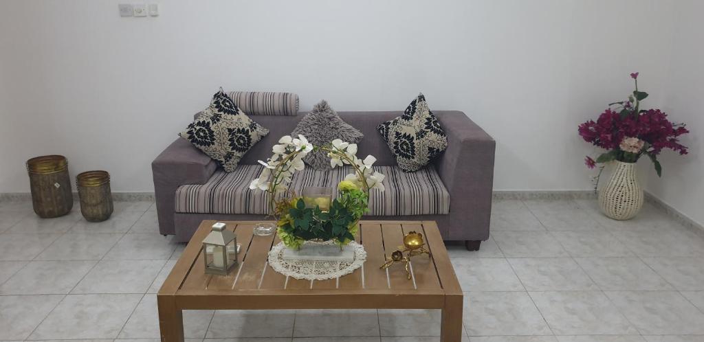 艾恩HOUSE IN AL AIN - 4的客厅配有沙发和鲜花桌