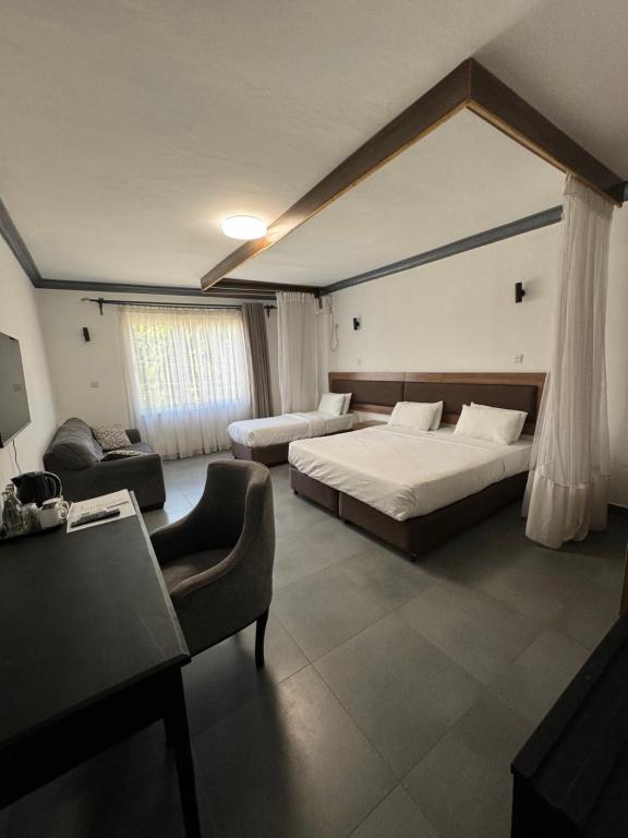 蒙巴萨Ivory Residences的一间卧室配有一张床、一张沙发和一把椅子