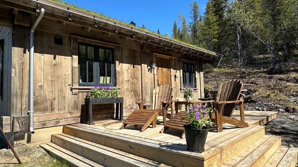 贝特斯托尔Liaplassen Mountain Chalet - Beitostølen的小屋设有两把椅子和一张桌子,位于甲板上