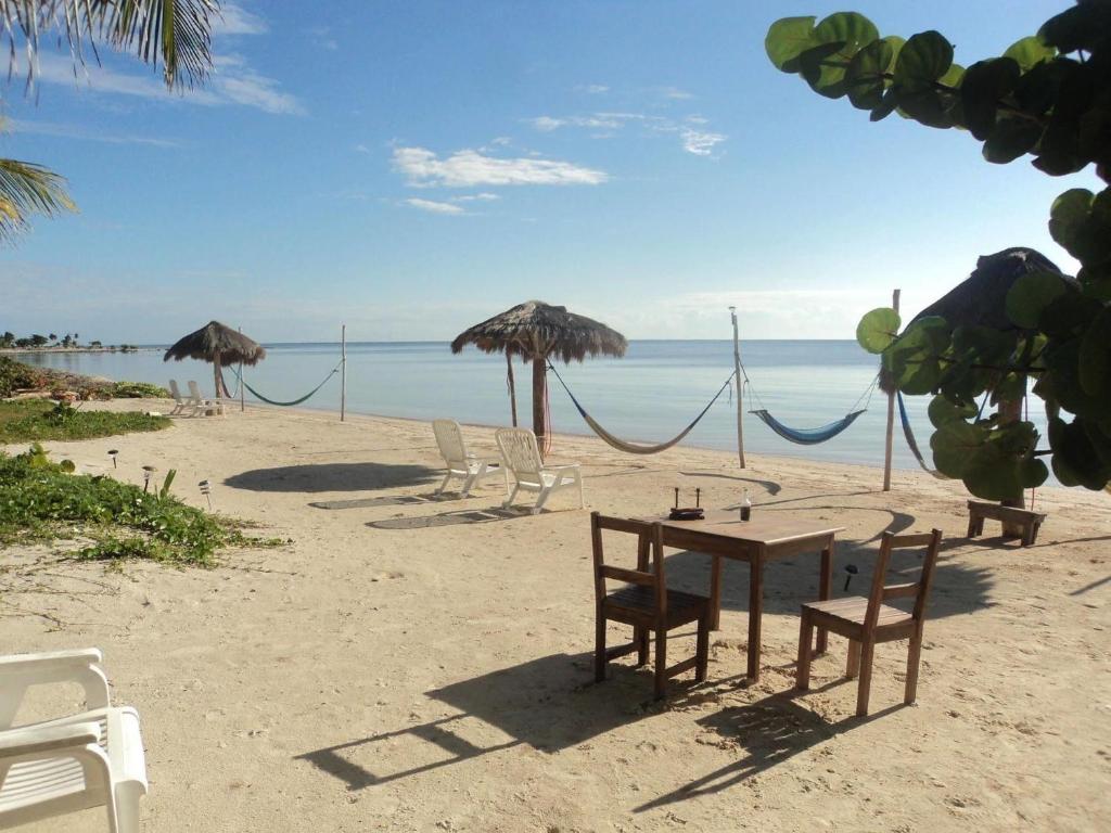 玛哈威Hotel Maya Luna Adults Only的海滩上摆放着椅子、桌子和遮阳伞
