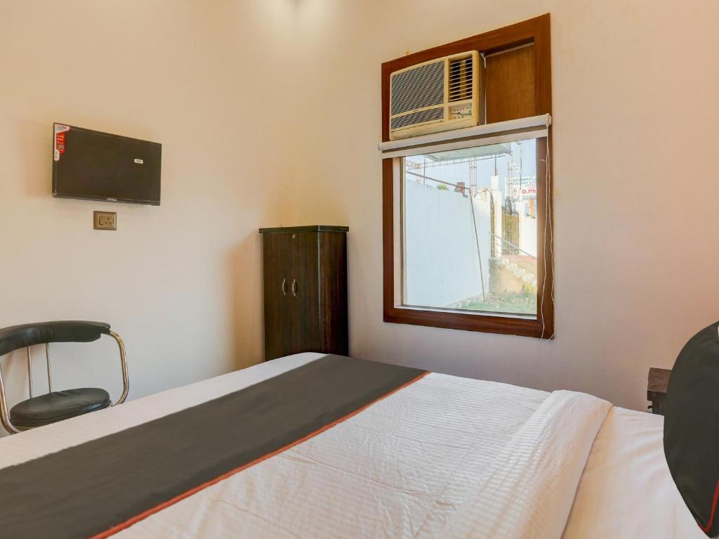 勒克瑙North Hotel & Lawn的一间卧室配有一张床,窗户配有空调