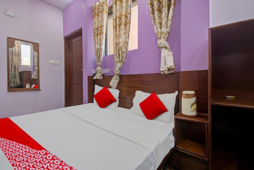 斋浦尔Hotel Rameshwaram的一间卧室配有红色和白色枕头的床