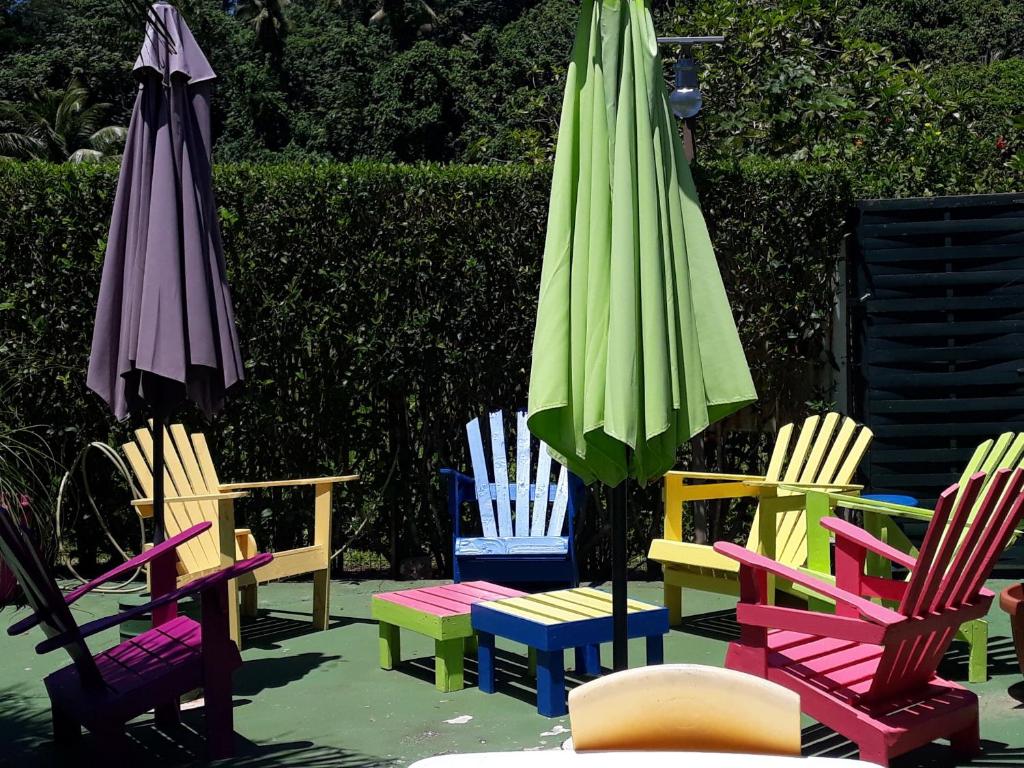 乌图罗阿提维皮特旅舍的一组五颜六色的椅子和一把雨伞