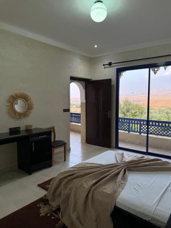 OuaouizeltMakhfamane Land的一间卧室设有一张床和一个大窗户