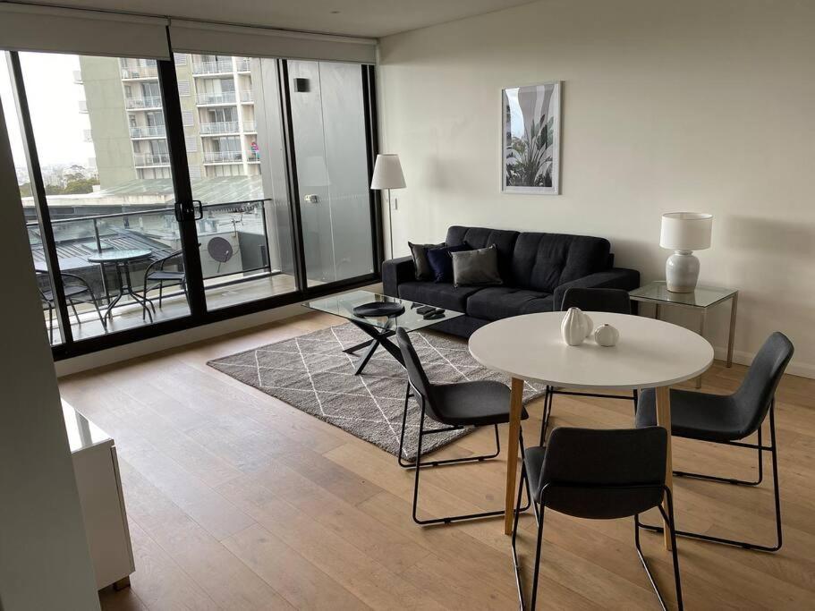 悉尼Stylish two bedroom in St Leonards ALB91105的客厅配有沙发和桌椅