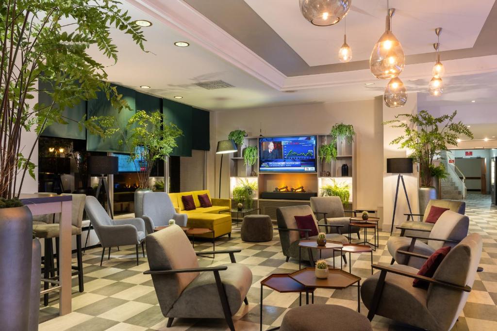 拉廷根莱昂纳多杜塞尔多夫机场拉廷根酒店的一间设有椅子和壁炉的等候室