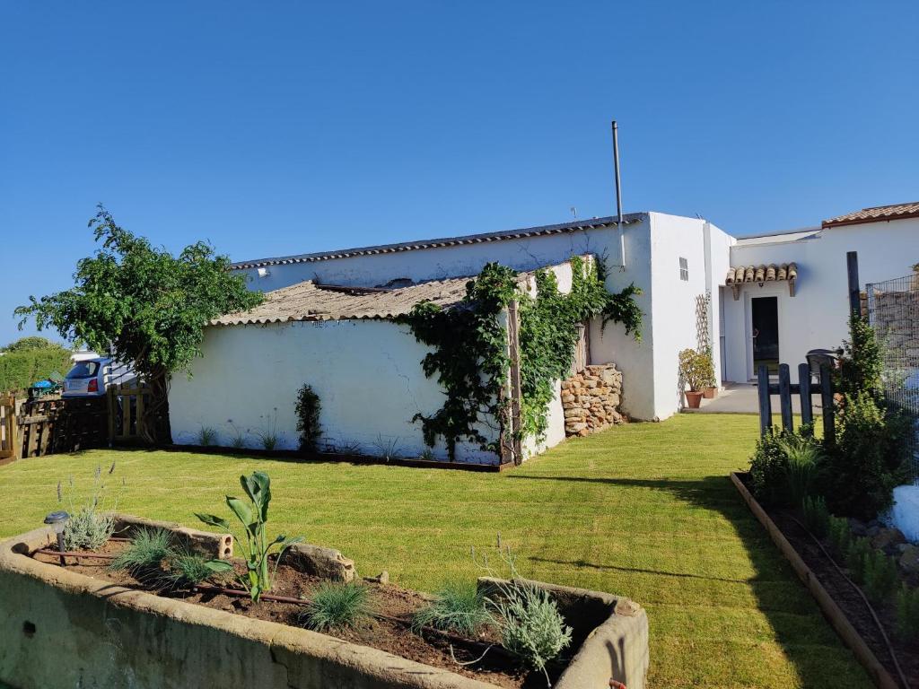科尼尔-德拉弗龙特拉Casa rural-Granja (La casa de la abuela Juana)的一个带草坪四柱形四柱形四柱形的院子的房子