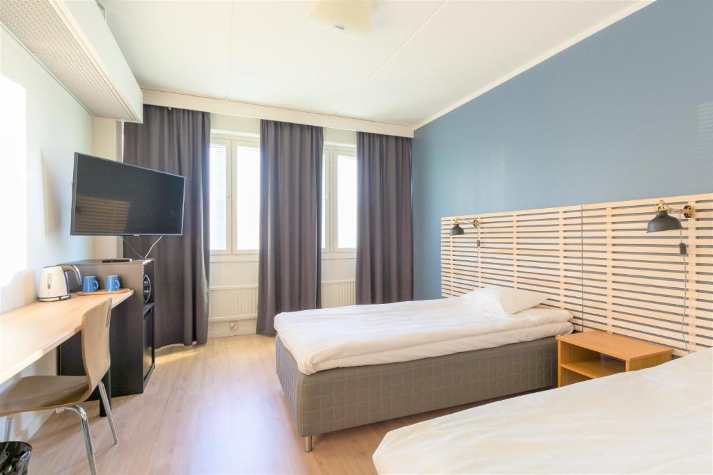 波里Torget Aparthotel的酒店客房配有两张床和一张书桌