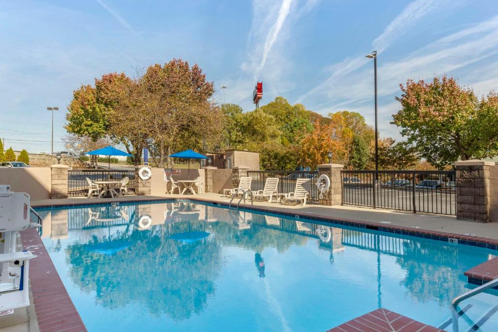 格林斯伯勒Comfort Inn Greensboro - Kernersville的一个带椅子和遮阳伞的大型游泳池