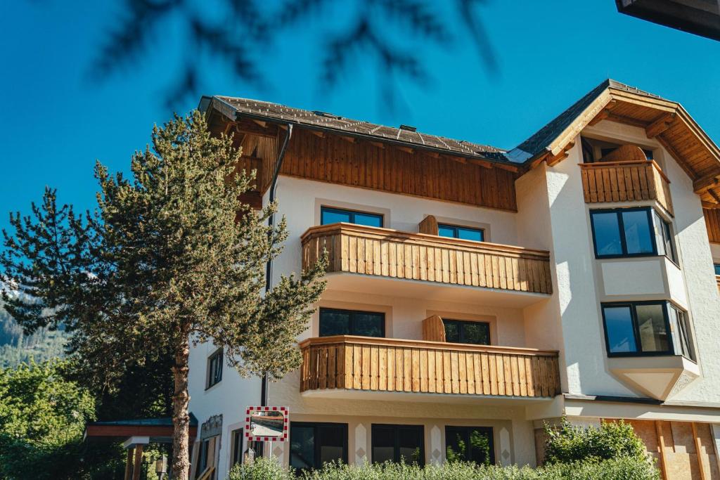 斯拉德明Stadtvilla Schladming Boutiquehotel的公寓大楼设有阳台和一棵树