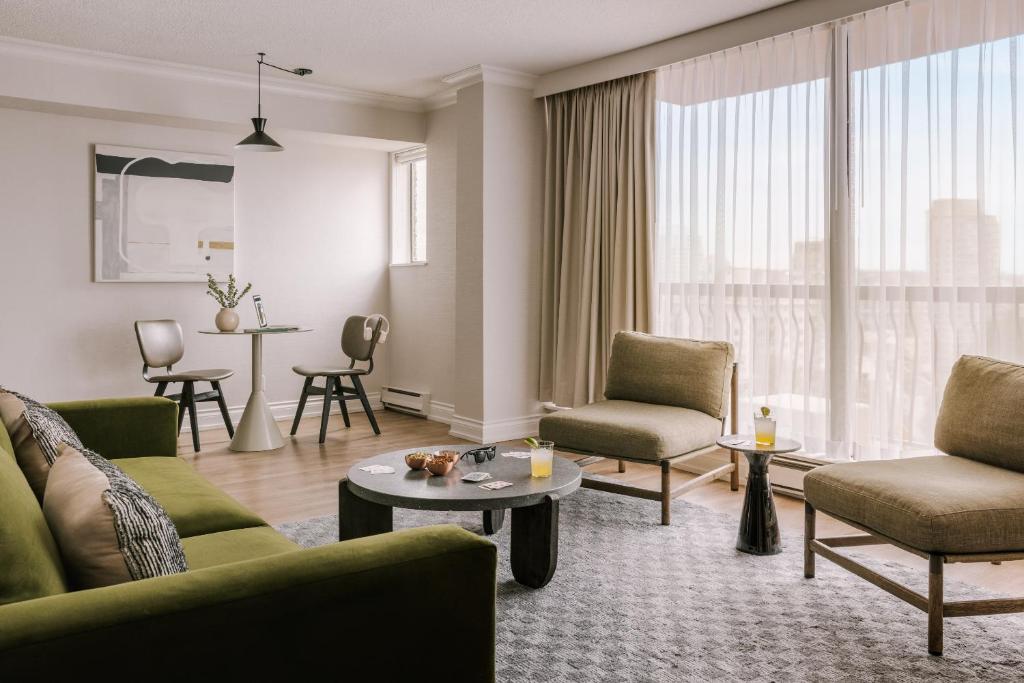 温哥华日落套房酒店的客厅配有沙发、椅子和桌子