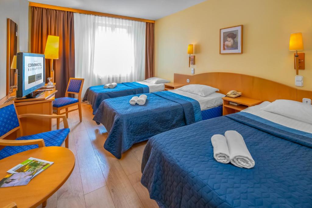 布达佩斯布达佩斯茜茜之翼柯文酒店的酒店客房设有三张床和电视。