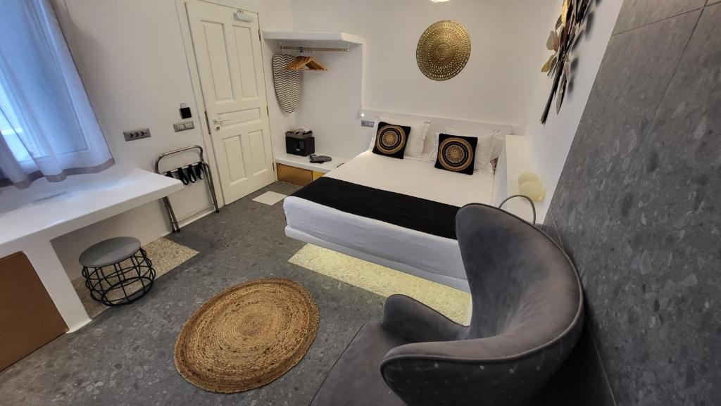 阿诺梅拉Mykonos Double Luxury Mini Suites - Adults only的一间小卧室,配有一张床和一把椅子