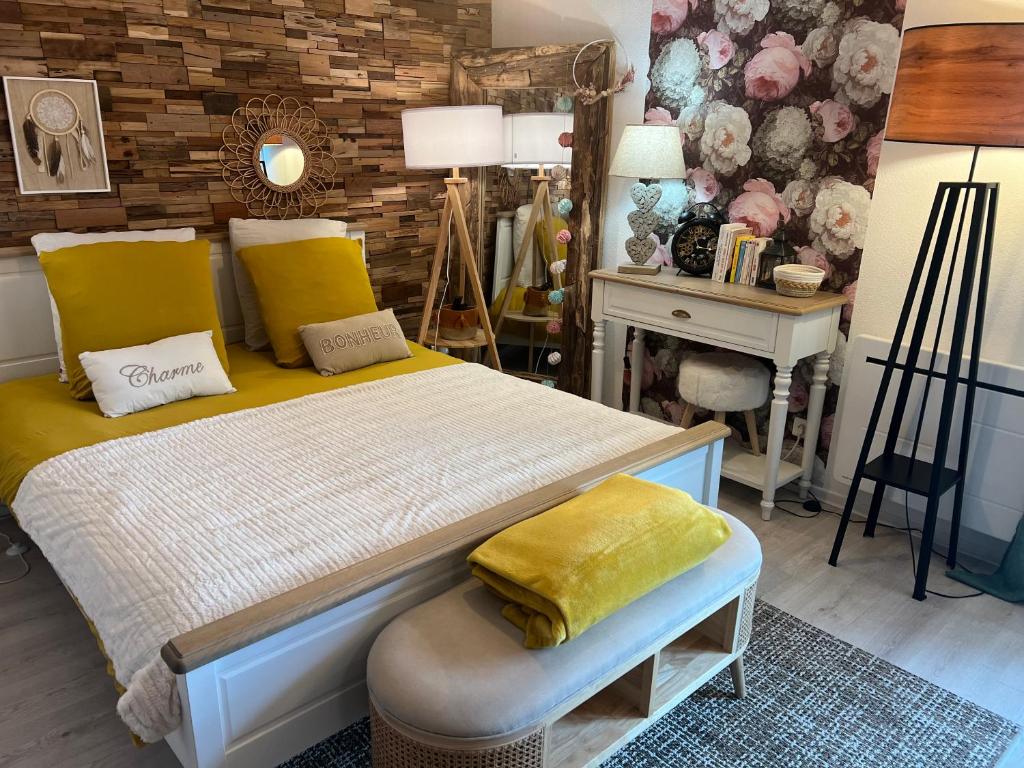 南希Petit cocon proche de Stanislas的一间卧室配有一张带黄色枕头的床和一张书桌