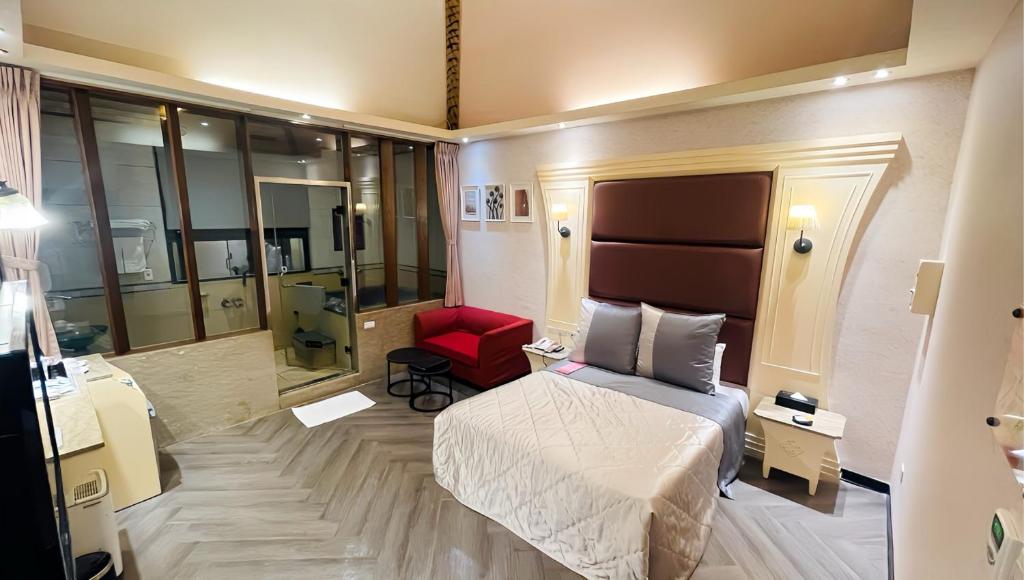 万里区金涌泉温泉汽车旅馆的酒店客房,配有一张床和一张红色椅子