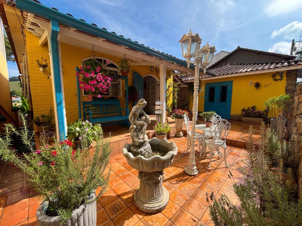 康赛瓦托利亚Pousada das Flores的房屋前方带喷泉的庭院