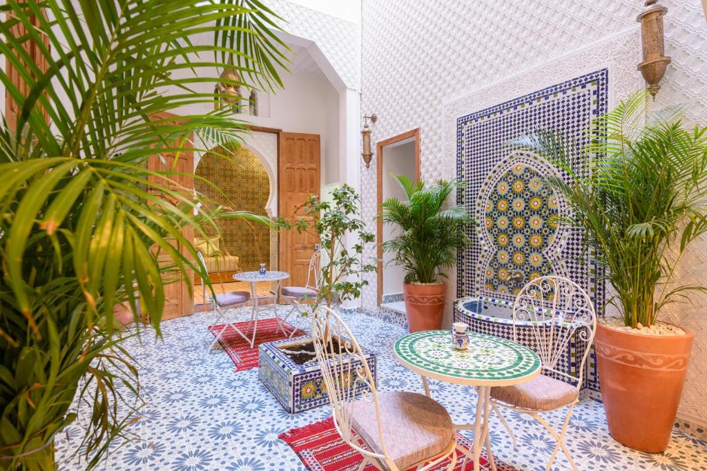 拉巴特Luxurious Riad Center Rabat Dar Al Jeld的庭院设有桌椅和植物