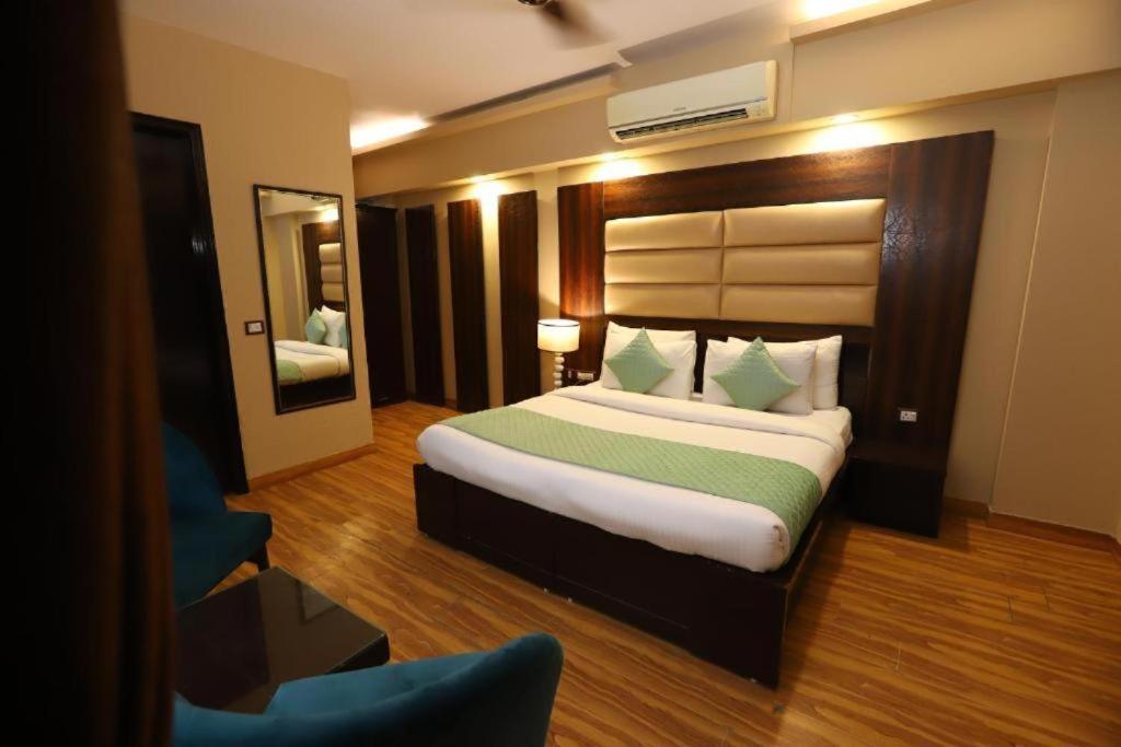 新德里Airport Hotel Peebles的一间卧室配有一张大床和镜子