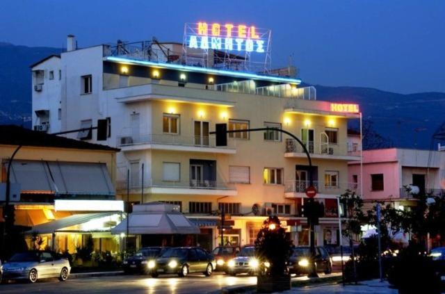 沃洛斯阿德米托斯酒店的上面有 ⁇ 虹灯标志的建筑