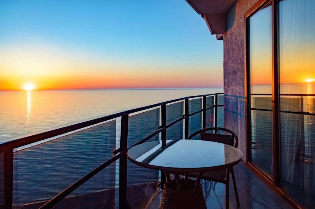 巴统sea view rooms in Batumi的阳台配有桌子,享有海景。