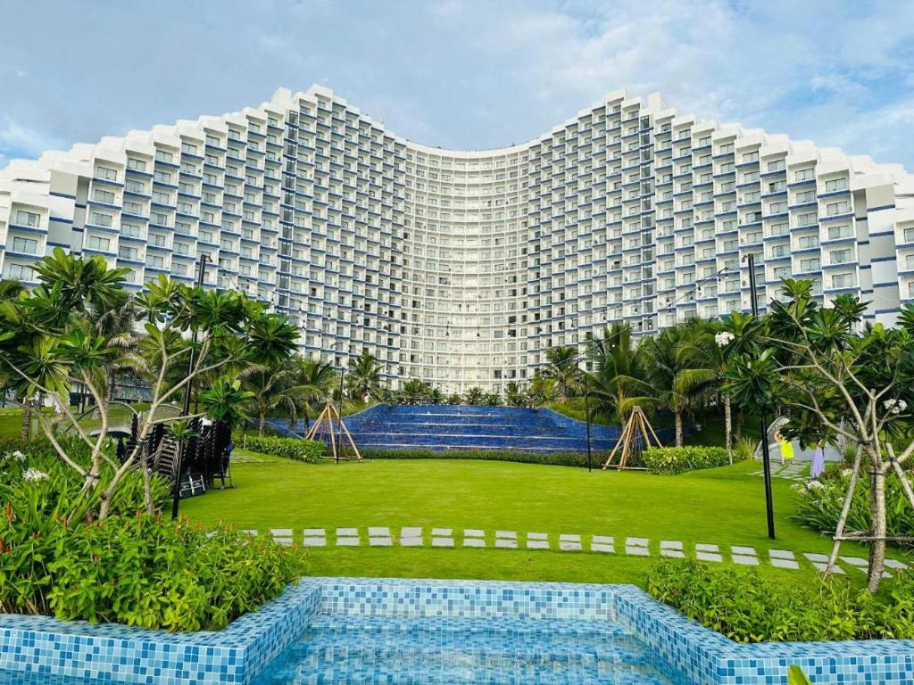 Thôn Hòa ÐaArena Cam Ranh Resort的一座大型建筑,前面设有一个游泳池