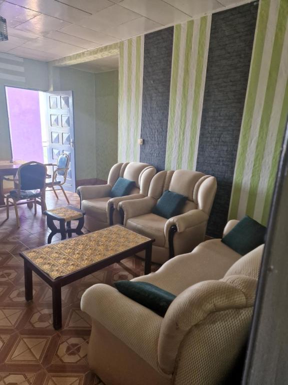 BafoussamBel Appartement meublé à Bafoussam的带沙发、椅子和桌子的等候室