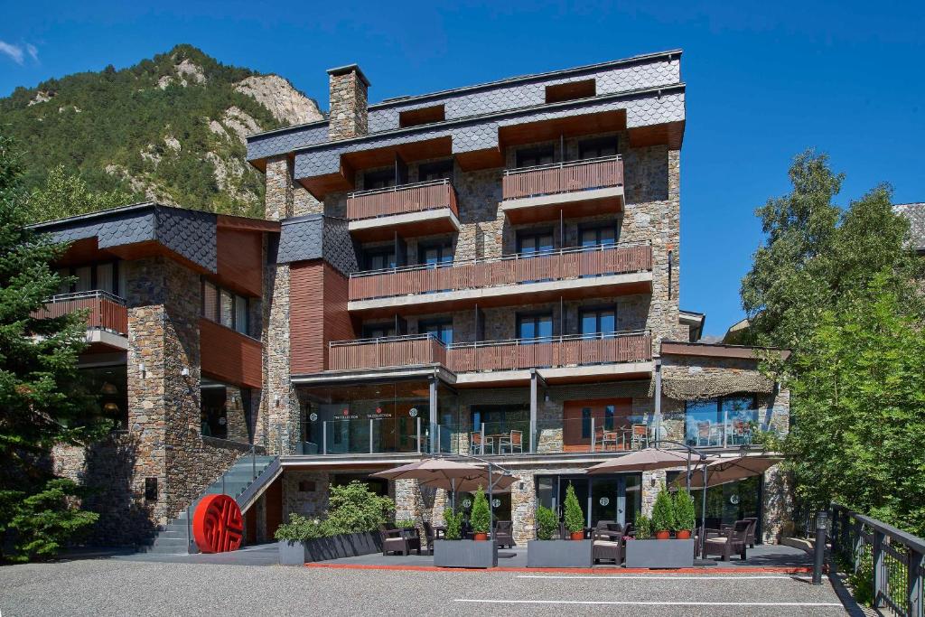 马萨纳NH Collection Andorra Palomé的一面有红色轮子的大砖砌体