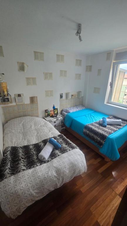 毕尔巴鄂Ganga Host 3的一间卧室设有两张床和窗户。