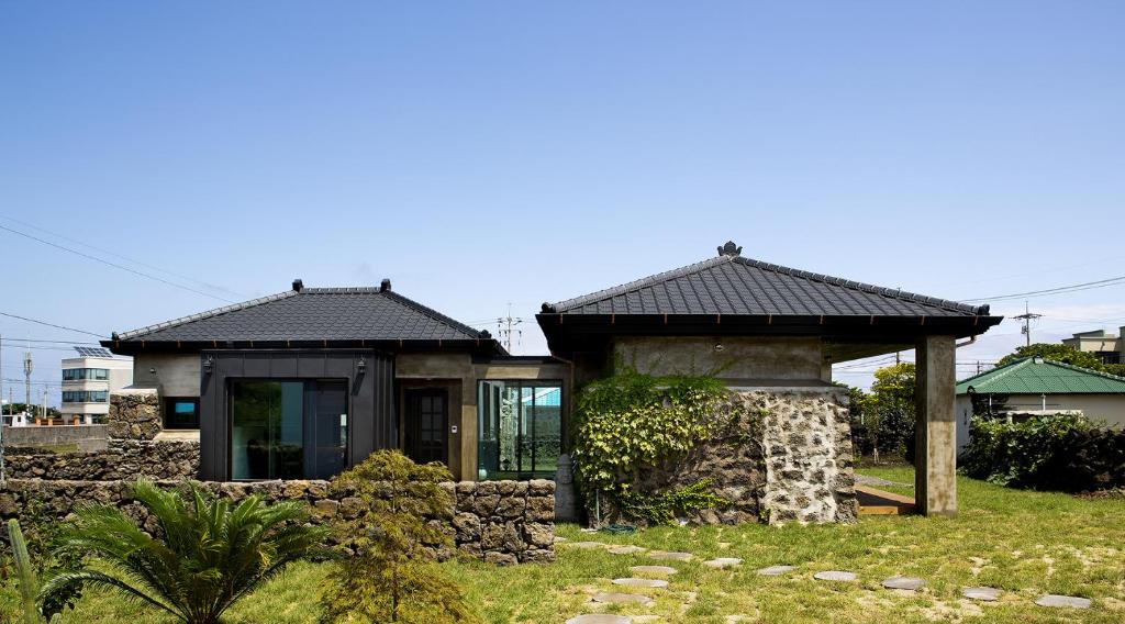 济州市蓬蓬度假屋的一座小房子,位于一个石头墙的院子内