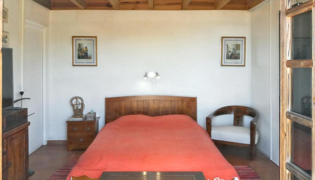 La MontagneStudio avec vue sur la mer piscine partagee et jardin clos a La Montagne的一间卧室配有红色的床和椅子