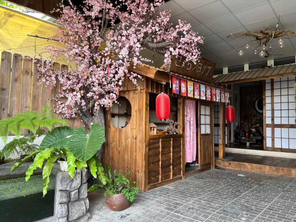 大叻SAKURA House ĐÀ LẠT的商店门前一棵开着粉色花朵的树