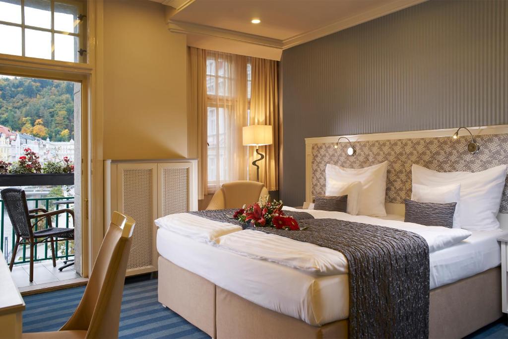 卡罗维发利EA Hotel Atlantic Palace的酒店客房设有一张大床和一个阳台。