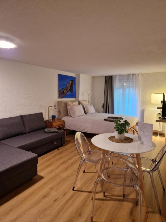 洛桑Studio SIEVA的客厅配有床、桌子和沙发