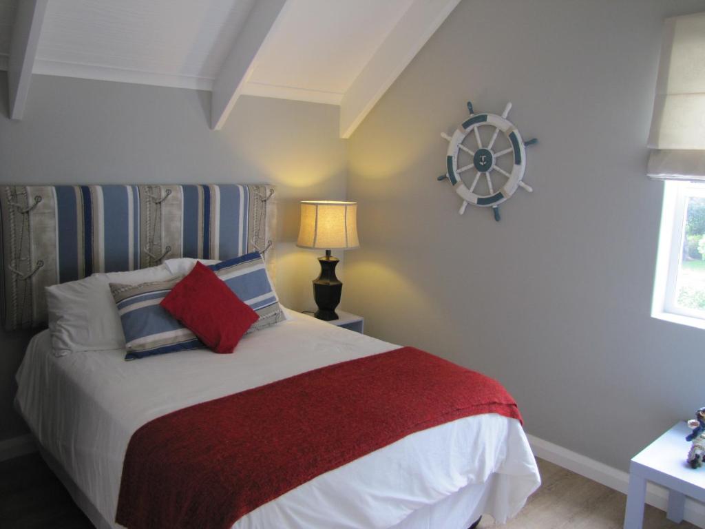 普利登堡湾Holiday Home Our Happy Place的一间卧室配有一张带红白毯子的床