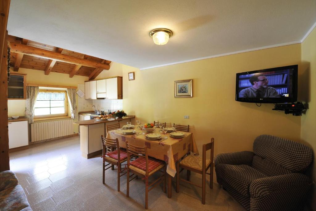 利维尼奥Genziana - Happy Rentals的厨房以及带桌子和墙上电视的用餐室。