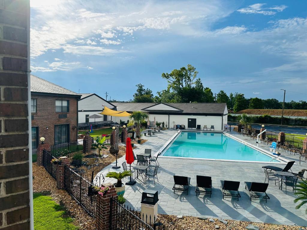 彭萨科拉At Home Inn - Pensacola的一座带庭院家具的游泳池和一座建筑