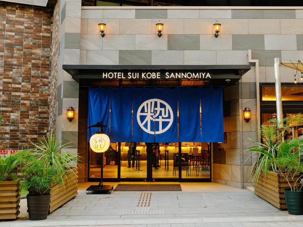 神户Hotel SUI Kobe Sannomiya by ABEST的大楼前方的酒店太阳节点的萨马敦标志