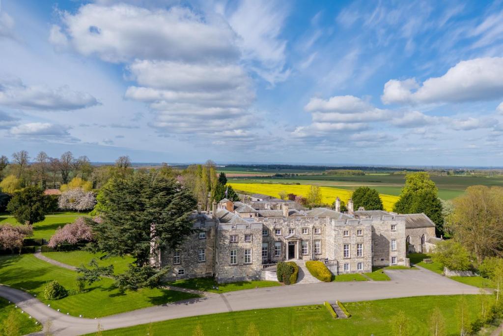 塔德卡斯特Hazlewood Castle & Spa的享有城堡的空中景致,拥有树木和草地