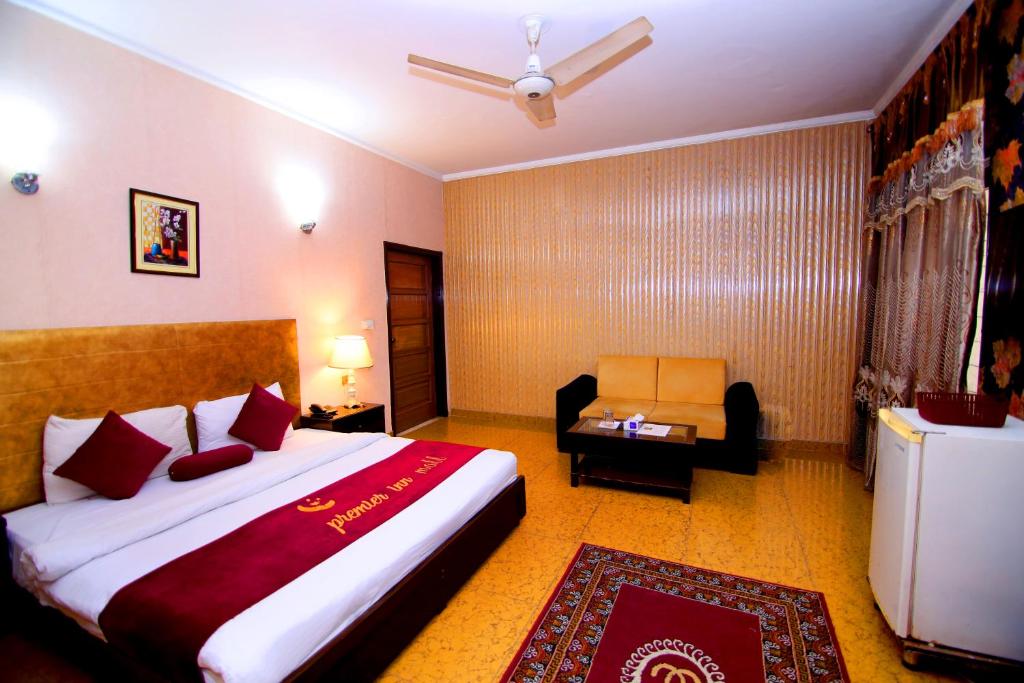 拉合尔Premier inn Mall Lahore的酒店客房带一张大床和一把椅子