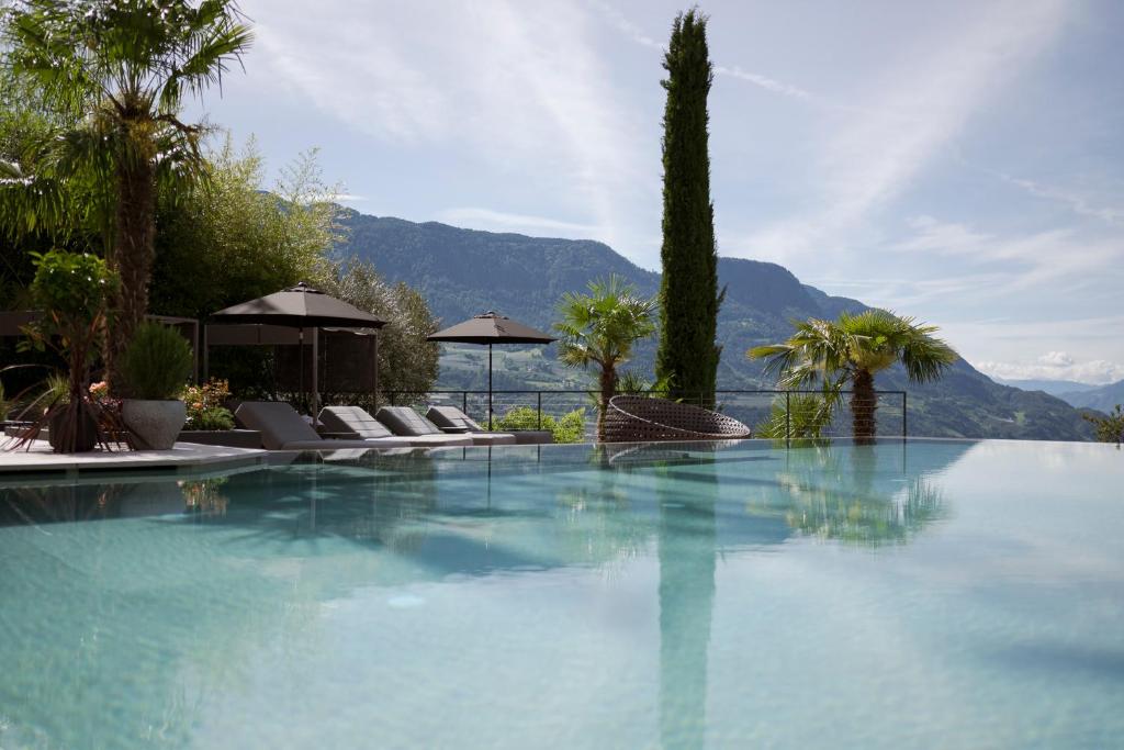 蒂鲁罗Feel good Resort Johannis的一个带椅子和树木的游泳池以及山