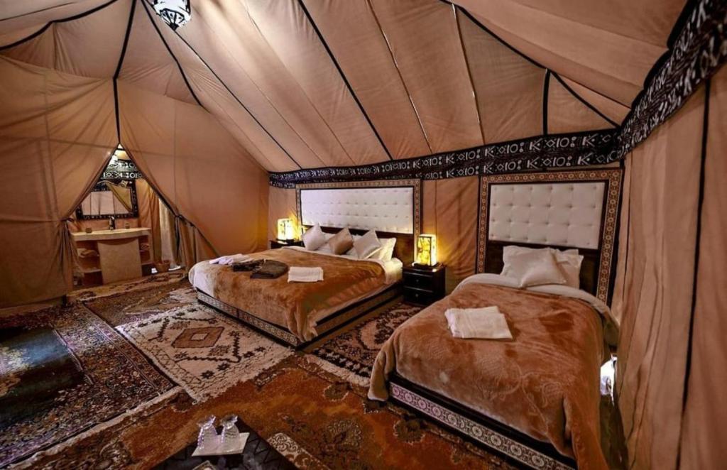 梅尔祖卡Merzouga Desert Awaite camp的一间帐篷内带两张床的卧室