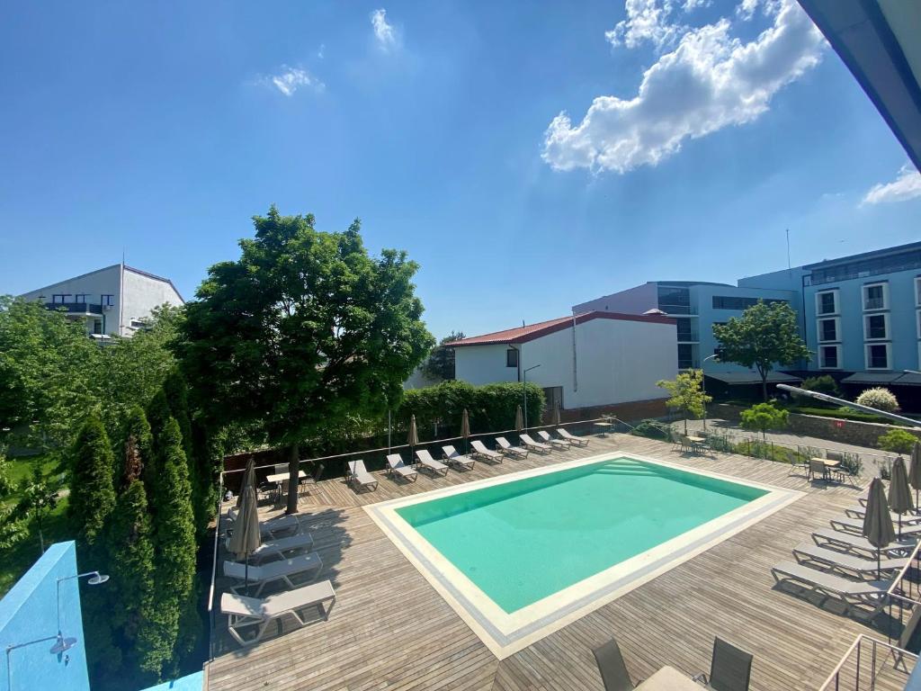 蒂米什瓦拉雷吉纳蓝色酒店的一个带躺椅的游泳池和一个游泳池