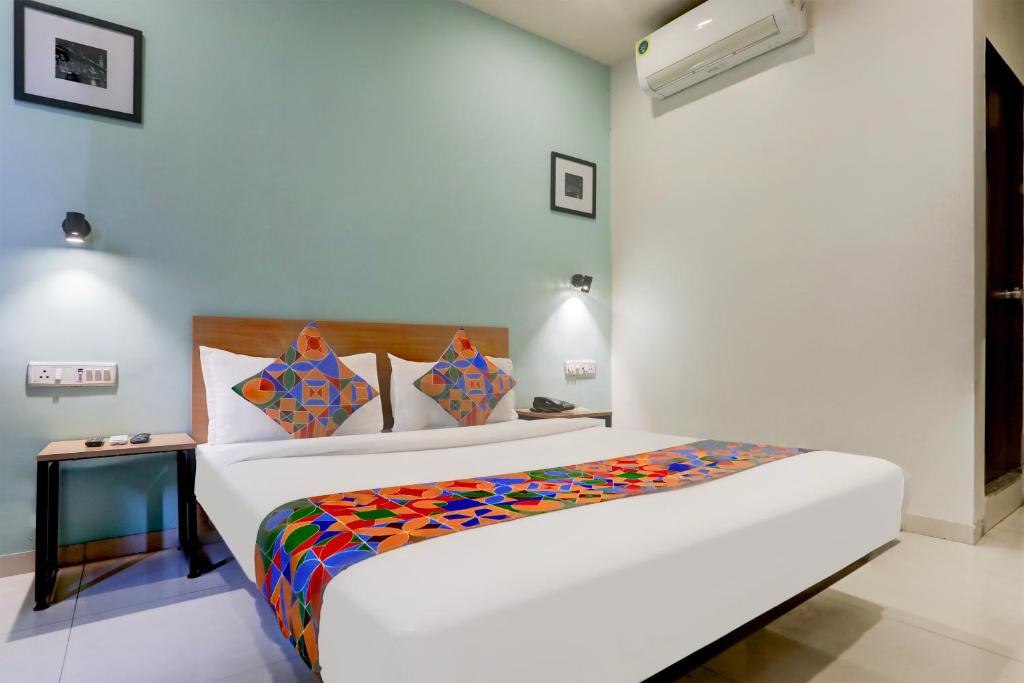 巴罗达FabHotel Prime Ace II的一间卧室配有一张大床和色彩缤纷的毯子