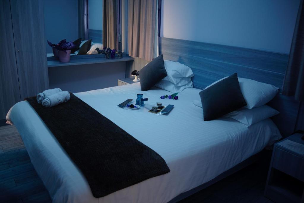 朱尼耶HOtello guest suites的一张位于酒店客房的床铺,上面有鞋和化妆品