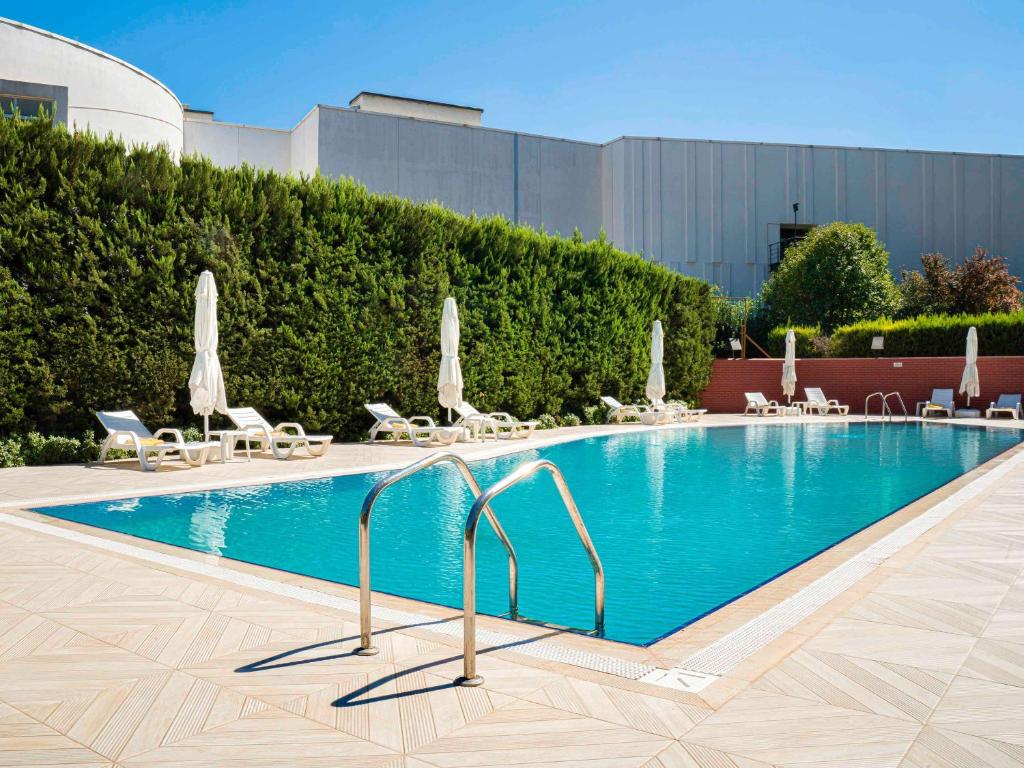 加济安泰普加济安泰普诺富特酒店的一个带椅子和遮阳伞的大型游泳池