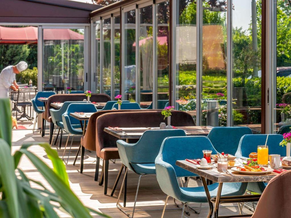伯萨宜必思布尔萨酒店的餐厅设有桌椅和窗户。
