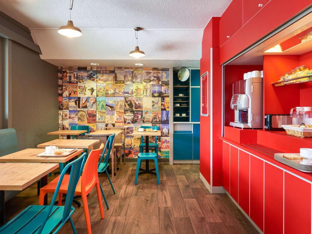 肖蒙hotelF1 Chaumont的一间带桌椅和红色墙壁的餐厅