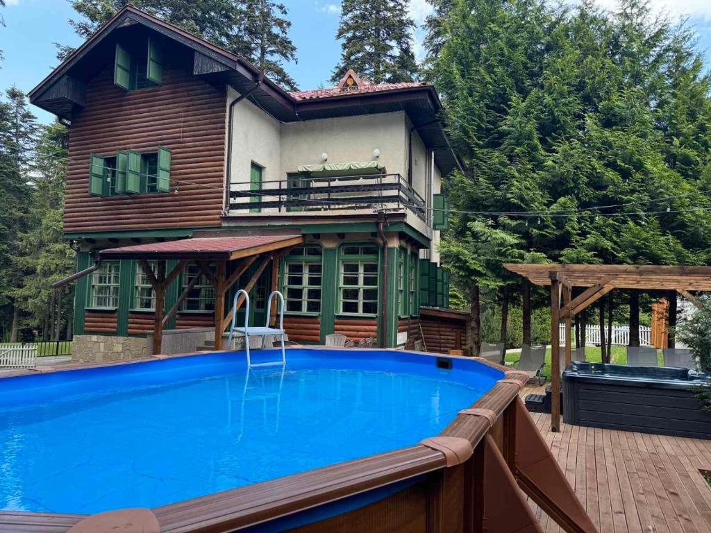 波罗维茨Villa Rila Borovets Mountain & Luxury with Hot Jacuzzi & Sauna的房屋前有游泳池的房子
