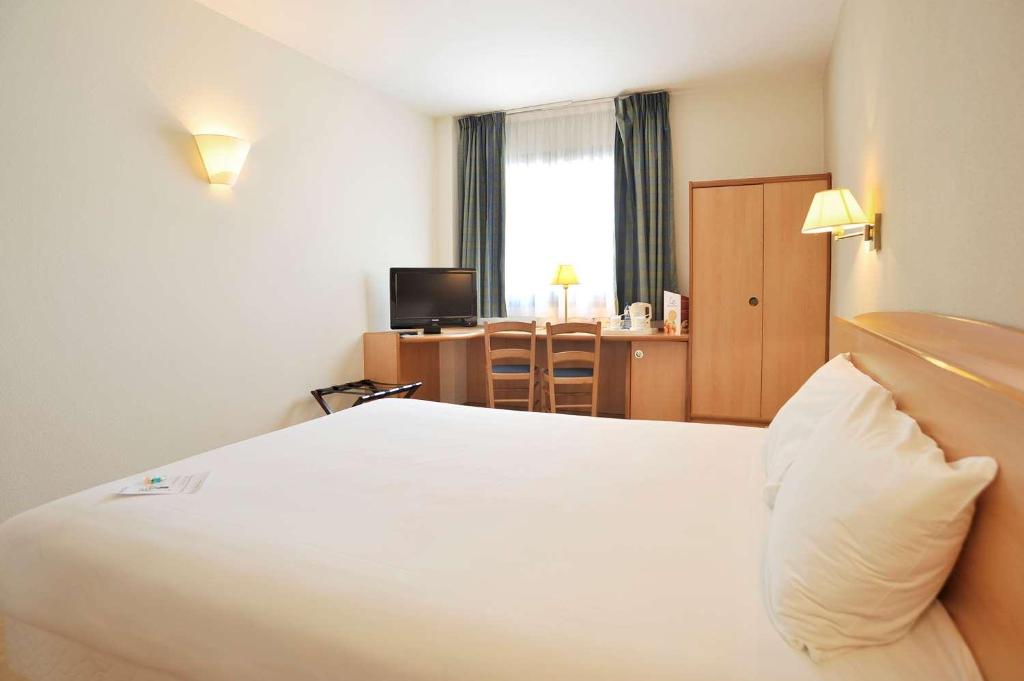 穆尔西亚Travelodge Murcia的一间酒店客房,配有一张白色的床和一张书桌